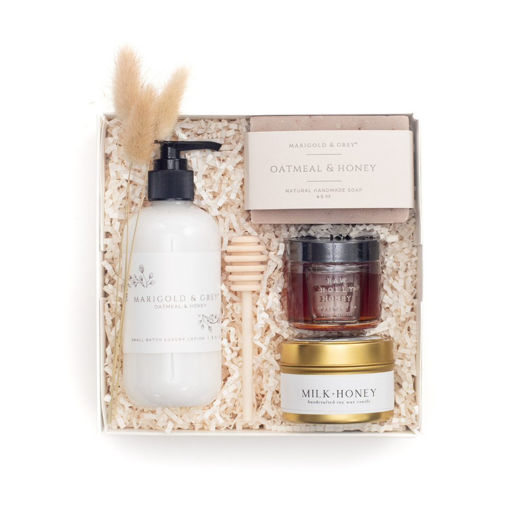 Gift set with self care products including lotion, bar of soap, candle and a small jar of honey
